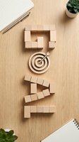 Wooden blocks arranged as speech bubble with target symbol in center, notebook and pen on natural wood surface, representing communication strategy and business goals.