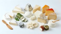 Assorted cheese varieties including soft, hard, and aged types with herbs and crackers on white background, suitable for food photography, culinary content, and gourmet lifestyle design.