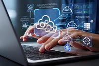 Business professional using laptop with cloud computing technology icons and data integration graphics floating above hands for digital transformation.