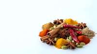 Aromatic spices collection with cinnamon sticks, star anise, turmeric, paprika and chili peppers isolated on white background for culinary cooking.