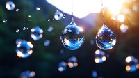 Crystal water drops suspended on threads catch sunlight creating magical bokeh effect against dark background. Natural macro photography with soft focus and blur.