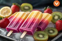 Colorful layered fruit popsicles with yellow and purple gradient on ice cubes, surrounded by fresh strawberries, kiwi slices and lemon, summer refreshment.