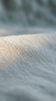 Close-up of natural linen fabric texture with soft focus background, showcasing woven material surface for textile, fashion, and interior design projects.
