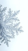 Macro close-up of crystalline snowflakes with intricate geometric patterns and ice formations on white background, suitable for winter, seasonal, and nature design projects.