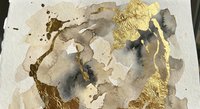 Abstract watercolor painting with gold foil accents on textured paper. Neutral earth tones blend with metallic elements creating organic flowing forms.
