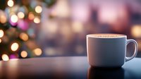 Blue ceramic coffee mug on wooden table with blurred Christmas tree lights creating warm bokeh background for holiday morning beverage concepts.