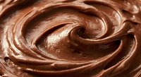 Rich creamy chocolate frosting with smooth swirled texture, perfect for cake decorating, baking projects, dessert backgrounds and culinary designs.
