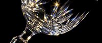 Elegant crystal wine glass with intricate cut patterns reflecting light against dark background for luxury dining and celebration concepts.