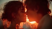 Young couple sharing intimate moment at golden hour sunset with warm bokeh lighting creating romantic silhouette against glowing sky for love and relationship concepts.