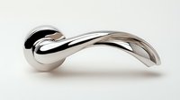 Sleek chrome metal sculpture with curved organic form featuring smooth polished surface and flowing lines against white background, isolated design element.
