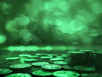 Stacked coins in green light with soft bokeh background creating magical money atmosphere. Financial concept showing wealth and prosperity.