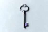 Vintage silver key with purple accent on white background, isolated object for design projects and creative layouts. Clean minimalist composition.