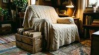 Cozy armchair draped with quilted throw blanket in warm, rustic living room with wooden furniture, bookshelves, and vintage decor for home interior design.