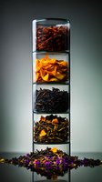 Stacked glass containers with various colorful dried tea leaves and flower petals, arranged vertically against dark background. Creative food photography for tea packaging.