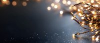 Glowing copper wire fairy lights creating magical bokeh effect against dark background, festive holiday atmosphere with copy space for text or design.