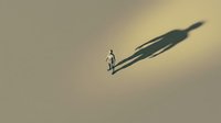 Businessman standing casting long shadow on neutral background, representing success, ambition, and professional growth in corporate environments.