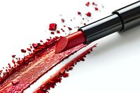 Red lipstick with smear and powder particles on white background, showcasing vibrant cosmetic product for makeup artistry and beauty industry.