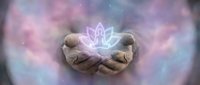Cupped hands holding glowing lotus flower symbol with ethereal purple pink energy aura background for spiritual healing meditation wellness concepts.