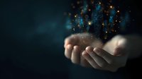 Magical glowing particles floating above cupped hands against dark background, creating mystical atmosphere with blue and gold sparkles for spiritual concept.