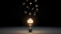 Glowing light bulb with floating science icons above on dark background representing innovation, creativity, research and scientific discovery concepts.