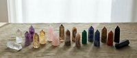 Collection of colorful healing crystal points and towers arranged on wooden surface for meditation, chakra balancing, and spiritual wellness practices.