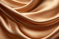 Smooth flowing waves of luxurious caramel satin fabric create elegant curves and folds against soft lighting, perfect for luxury product backgrounds and design elements.
