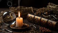 Mystical fortune telling setup with burning candle, crystal ball, ancient scrolls and coffee beans creating atmospheric divination scene for spiritual practices.