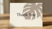 Elegant thank you card on wooden surface with monstera leaf shadow, minimal style for greeting, wedding, or appreciation design.