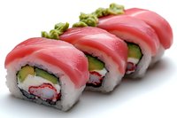 Fresh tuna sushi rolls with cucumber, crab meat and avocado on white background. Close up view of traditional Japanese maki rolls garnished with wasabi.