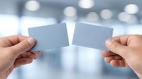 Two hands holding blank business cards ready to connect in modern office environment with soft bokeh lighting background for networking concepts.