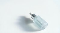 Glass dropper bottle with silver cap isolated on white background for skincare and cosmetic product packaging design.