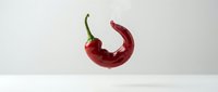 Red chili pepper with green stem isolated on white background, ready for culinary, food packaging, and recipe design projects.