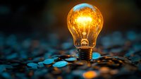 Glowing light bulb on dark surface with warm illumination representing innovation, creativity, and bright ideas for business concepts.