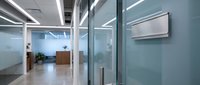 Modern office interior with glass walls and reception desk featuring clean minimalist design and professional lighting for corporate business space.
