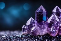 Purple amethyst crystal cluster with pointed formations on dark surface against blue bokeh background for healing meditation and spiritual wellness.