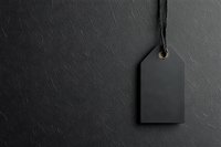Black blank price tag hanging on dark textured background with copy space. Minimalist retail mockup for branding and sale design.