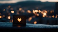 Glowing heart cutout in paper lantern against blurred city lights at dusk creates romantic atmosphere. Bokeh effect adds dreamy mood to evening cityscape.