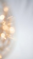 Soft golden bokeh lights creating dreamy atmosphere on blurred white background for holiday decorations and festive celebrations.