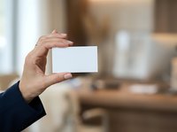 Mature adult male hand holding blank white card in modern office environment for business networking and professional contact exchange.