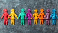 Colorful paper cutout figures holding hands in row on dark concrete background, symbolizing unity, diversity, inclusion and community connection.