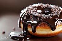 Chocolate glazed donut with dripping dark chocolate sauce and sprinkles on wooden surface, extreme close up macro food photography in warm tones.