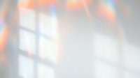 Soft blurred rainbow light reflections creating dreamy prismatic effects on white surface for backgrounds and overlays.