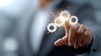 Businessman touching glowing digital gears interface, representing business process automation and digital transformation technology solutions.