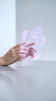 Hand holding transparent pink neon glass panels with glowing light effects on white background. Futuristic technology concept for digital design, UI interface, and modern innovation projects.