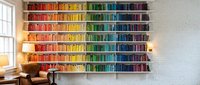 Colorful rainbow bookshelf with organized books by color creating vibrant home library wall display for modern interior design and reading space decoration.
