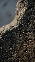 Close-up macro view of rich dark soil texture with organic matter and granular structure for agriculture and gardening applications.