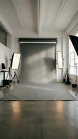 Professional photography studio setup with gray backdrop and lighting equipment for commercial shoots.