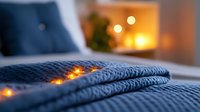 Cozy knitted navy blue blanket with warm glowing fairy lights creating intimate atmosphere in bedroom. Soft focus bokeh effect adds romantic mood.