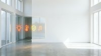 Modern empty loft space with polished concrete floor, large windows, and glowing neon icons on glass wall displaying lightbulb, leaf, shield, and music note symbols for creative business concepts.
