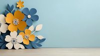Paper craft floral arrangement with yellow, blue and white flowers against light blue wall and wooden surface. Decorative 3D layered botanical composition.